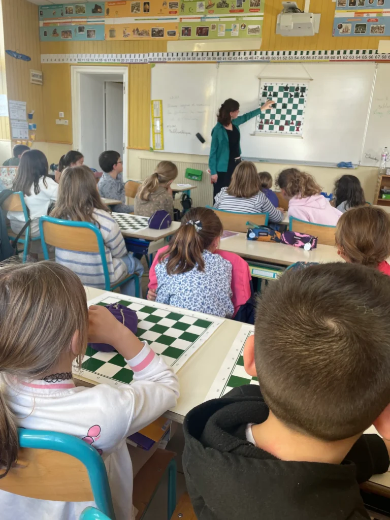 Animatrice montrant une position d'échecs au tableau. 