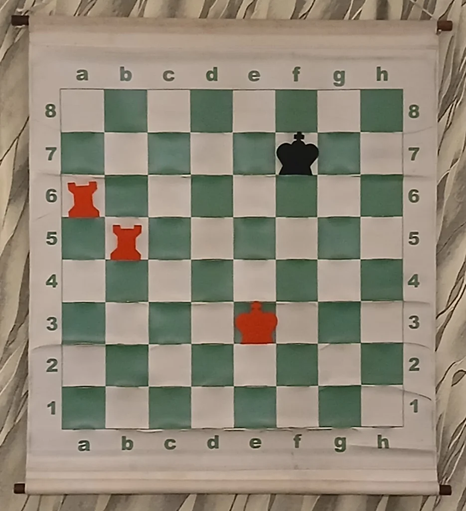 Échiquier mural montrant une position où les blancs matent en deux coups grâce au mat de l'escalier.